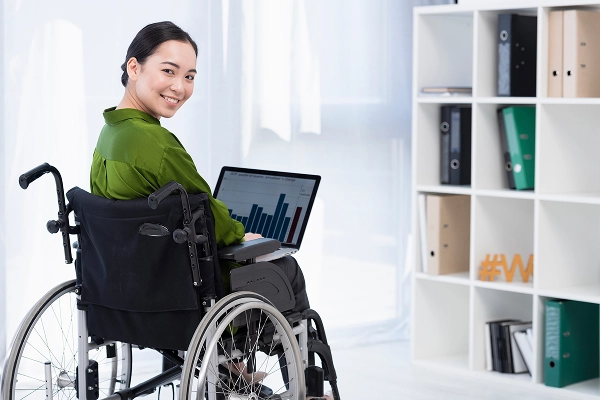 girl on wheelchair using laptop
